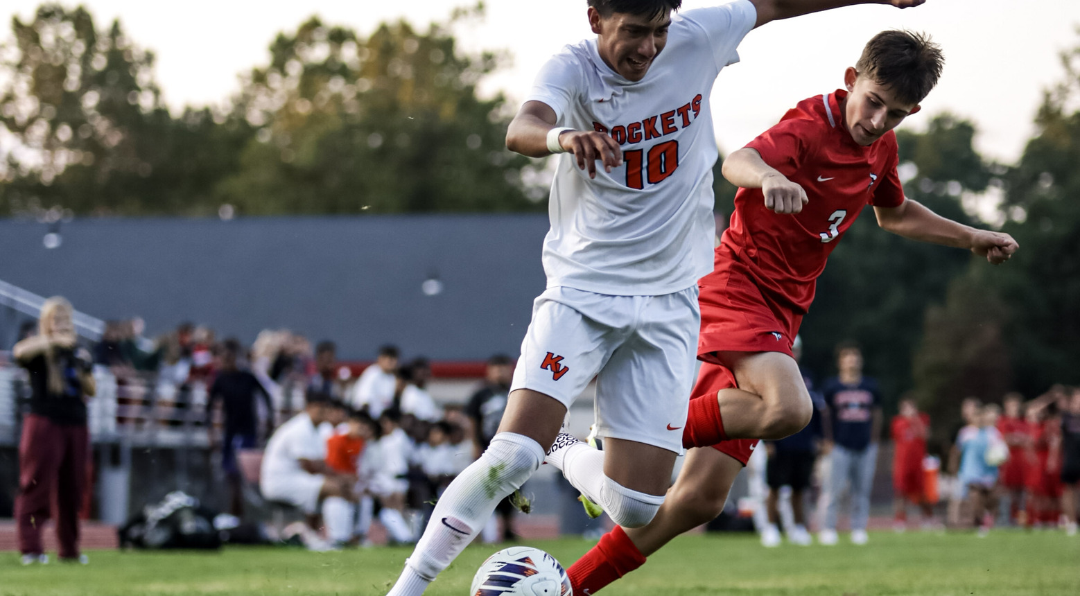 Soccer player running to kick the ball on the field.