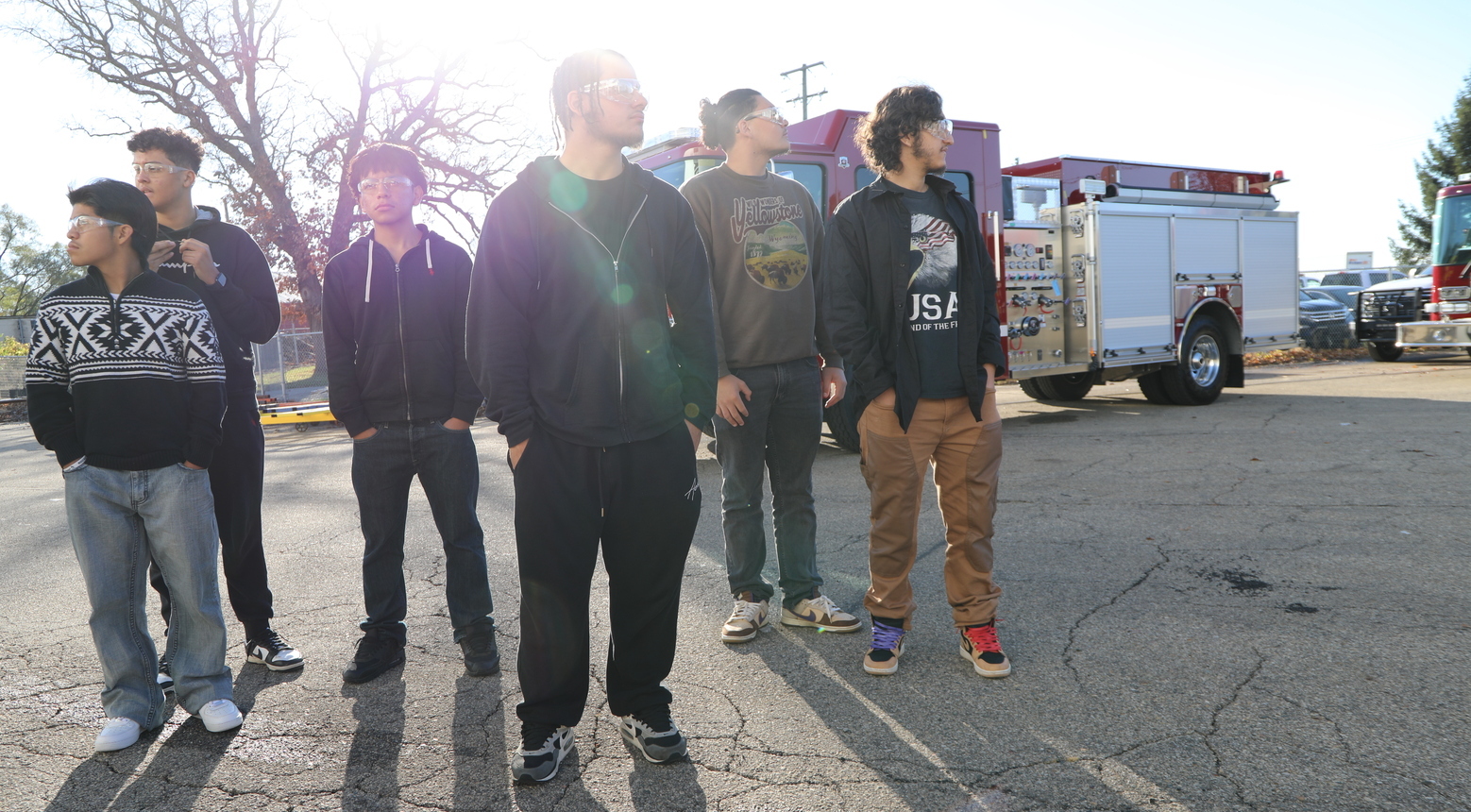Students in a parking lot looking around.