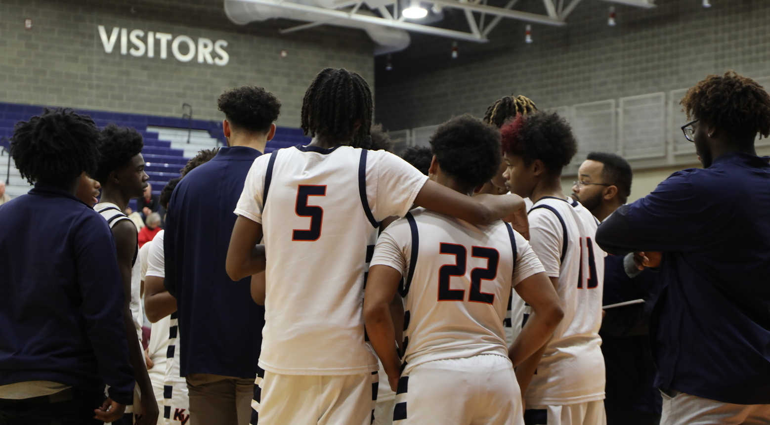 Basketball players huddling together during timeout.