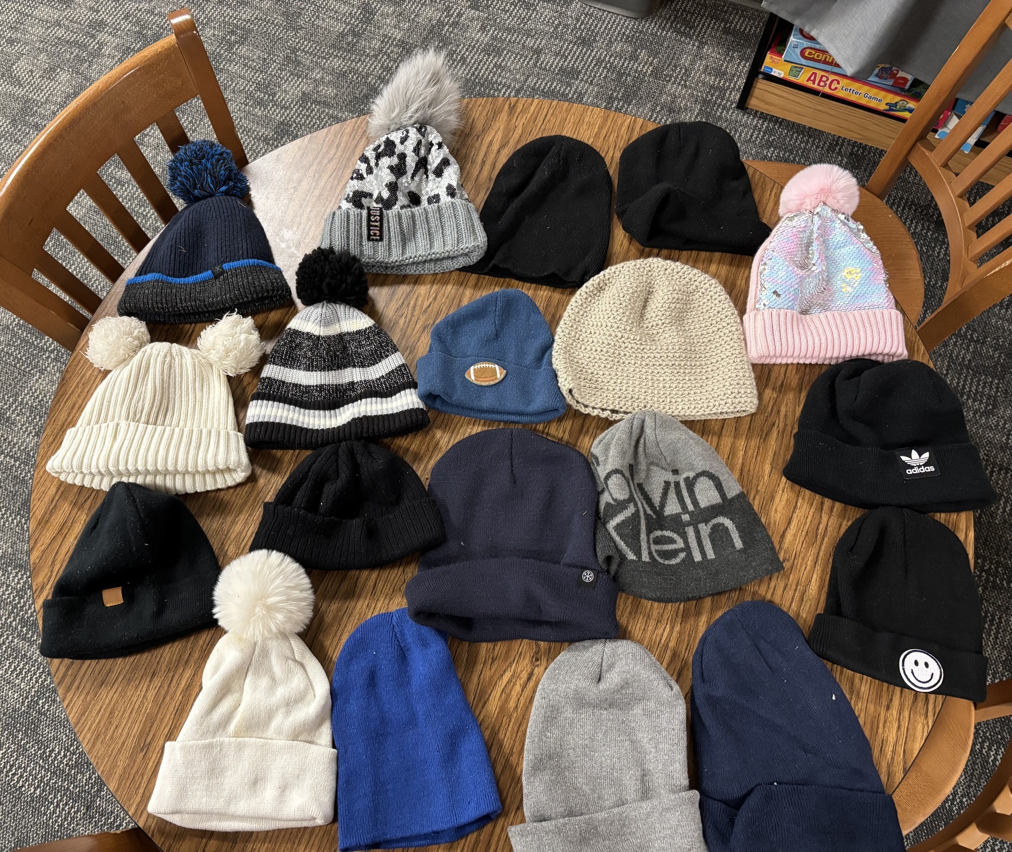 Winter hats laid out on a large table.