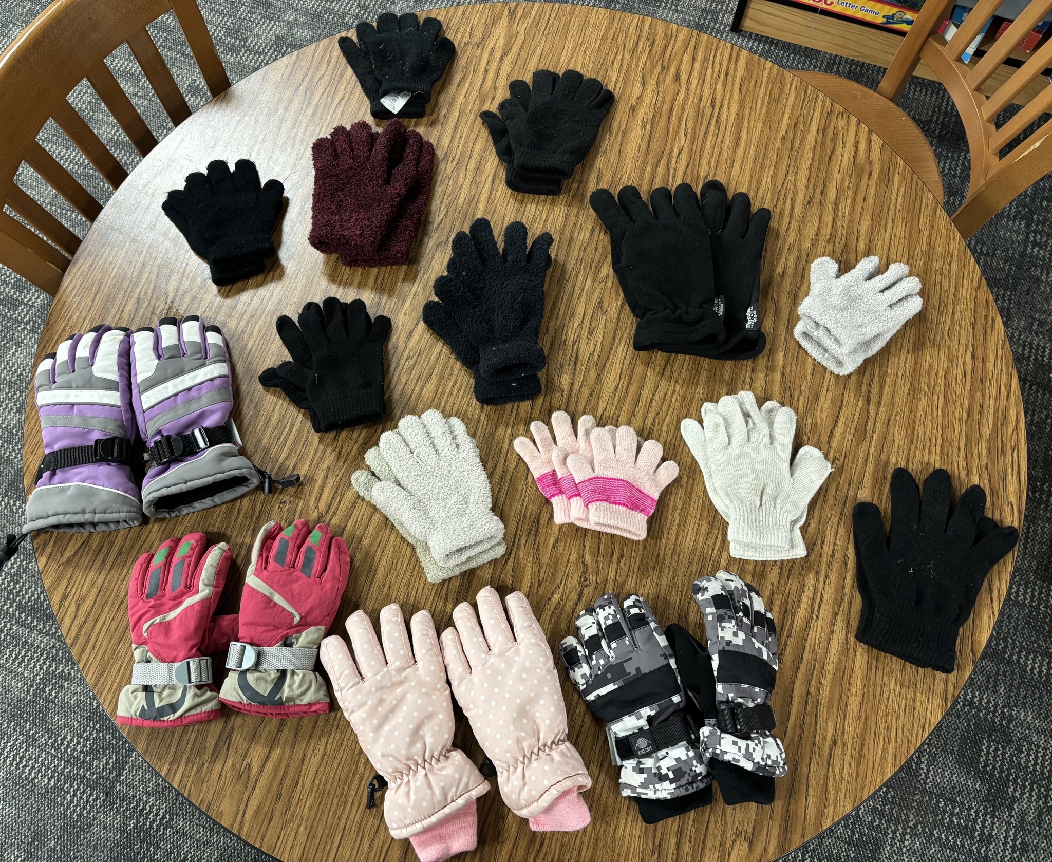 Winter gloves laid out on a large table.