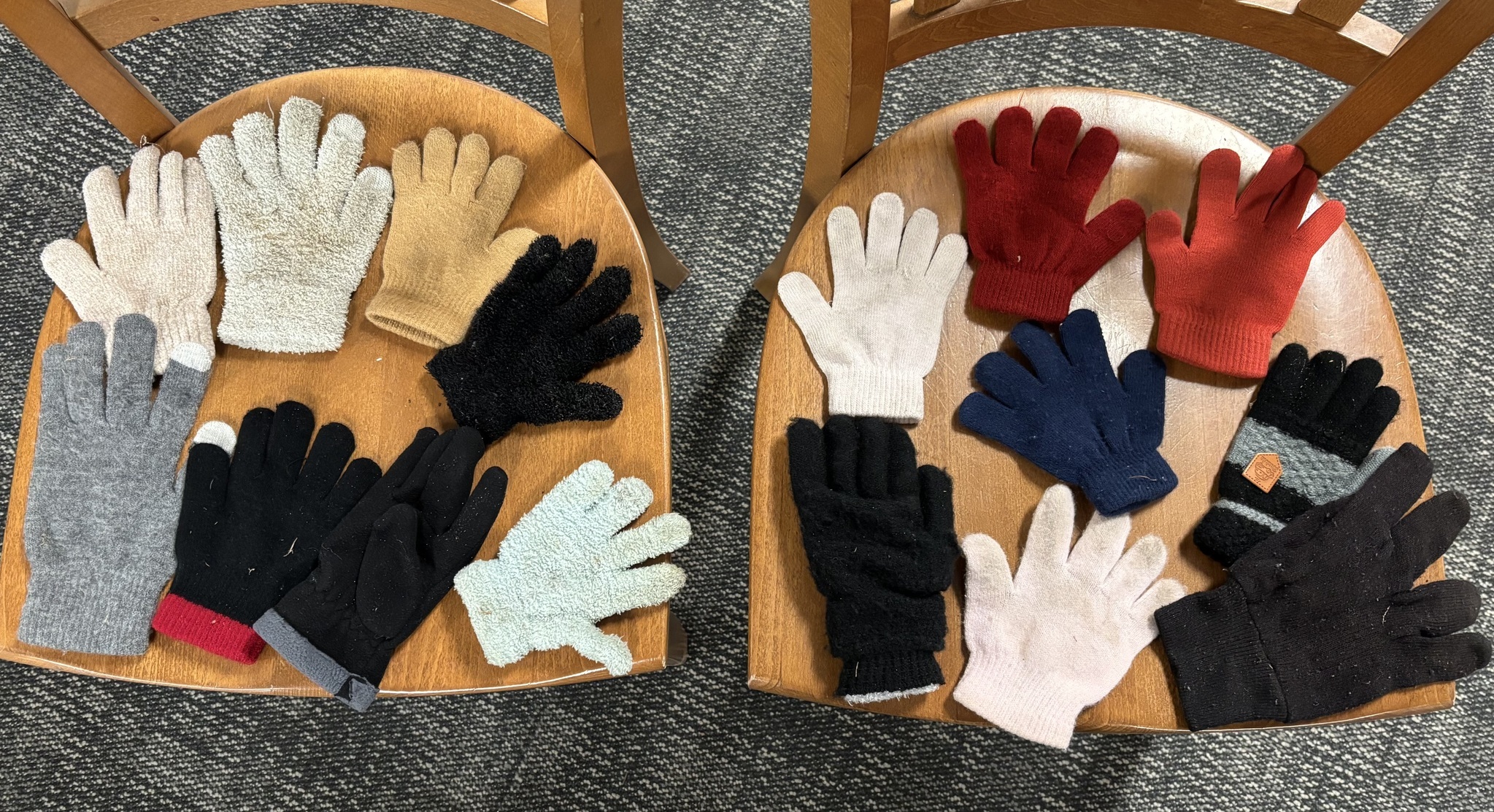 Winter gloves laid out on two chairs.